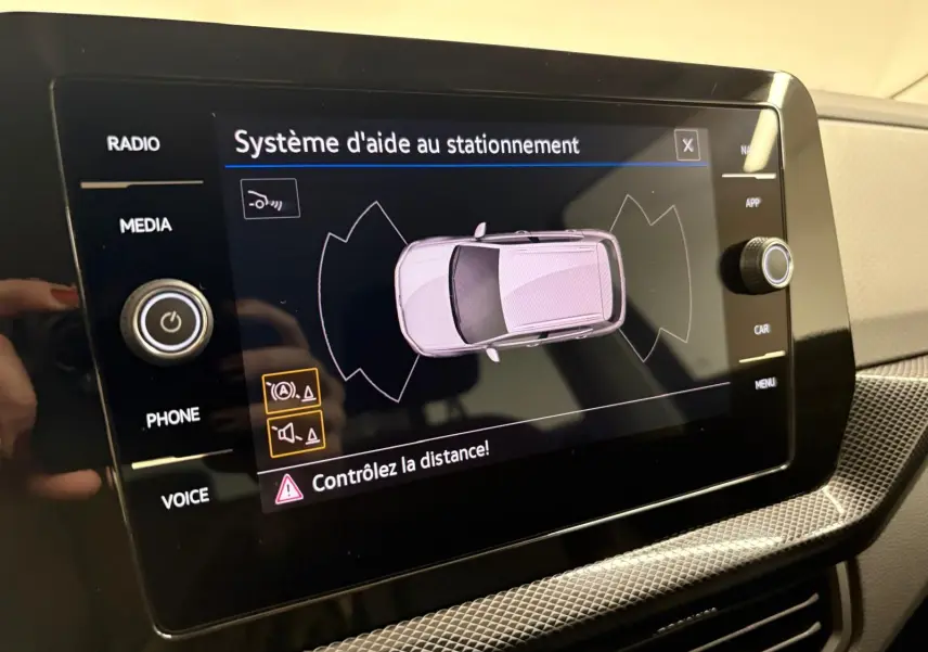 Écran tactile du système d'aide au stationnement du Volkswagen T-Cross 2024 affichant une vue aérienne du véhicule.