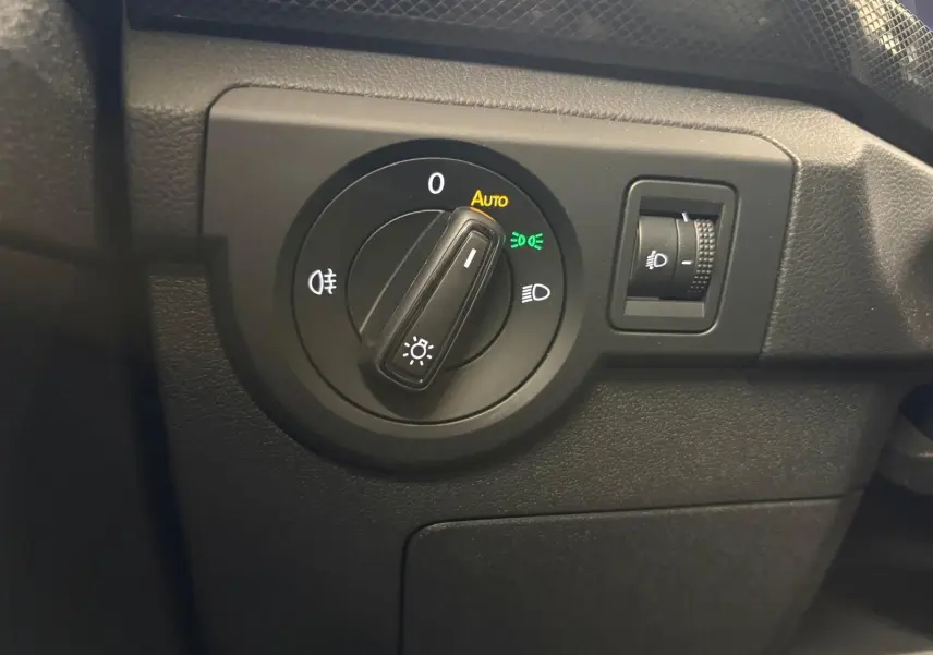 Gros plan sur le sélecteur d'éclairage noir du tableau de bord du Volkswagen T-Cross 2024 finition Life Plus.