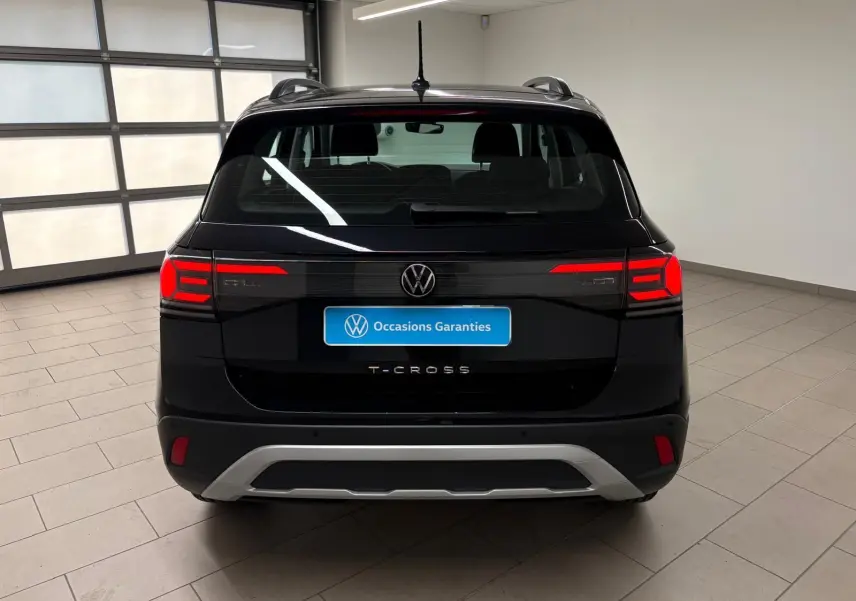 Vue arrière du Volkswagen T-Cross noir intense 2024 avec feux rouges allumés et logo VW bien visible.