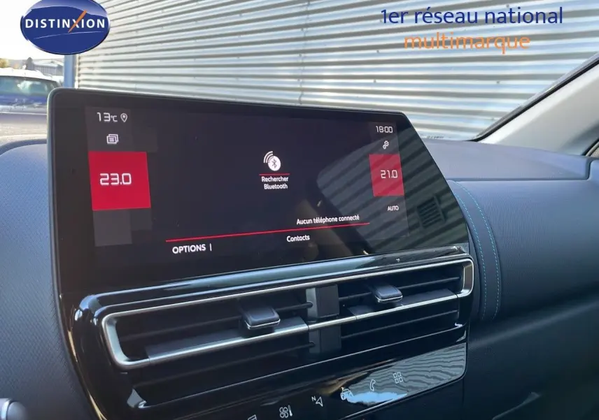 Vue intérieure du tableau de bord et écran tactile du Citroën C5 Aircross 2025, finition cuir noir avec surpiqûres bleues.