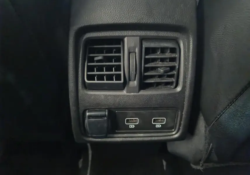 Gros plan sur la console arrière noire du Renault Captur 2024 avec bouches d’aération et deux ports USB.