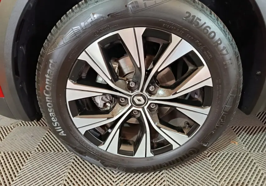 Gros plan sur la jante alliage bicolore noire et argent avec logo Renault au centre, roue du Captur rouge 2024.