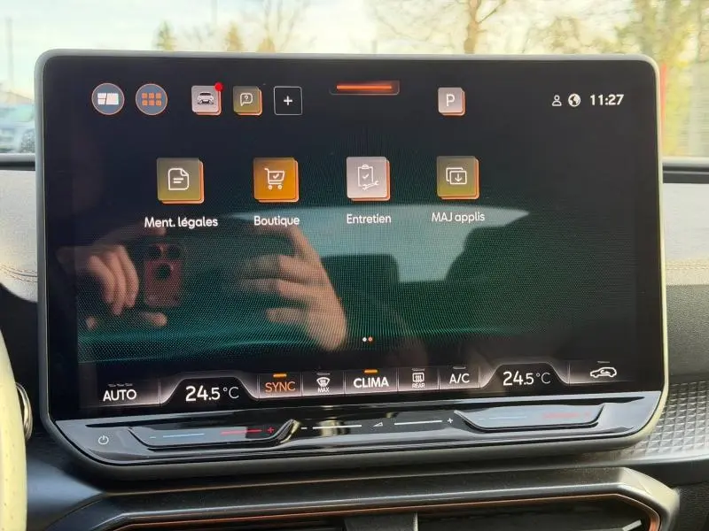 Écran tactile central du tableau de bord de la SEAT LEON 2025, affichant les menus d'entretien et boutique, avec commandes climatisation visibles.