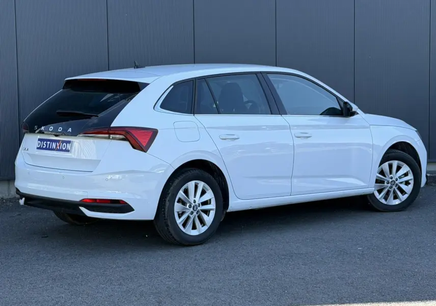 Vue 3/4 arrière droite d'une Skoda Scala blanc glacier avec lunette arrière noire et jantes alliage 16 pouces.