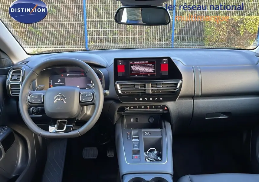 Vue intérieure avant du tableau de bord et volant du Citroën C5 Aircross 2025, finition cuir noir avec écran tactile central.