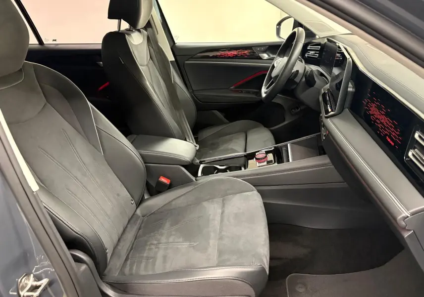 Vue intérieure côté conducteur du Volkswagen Tiguan 2025 gris Dauphin, sièges en cuir et alcantara avec tableau de bord numérique.