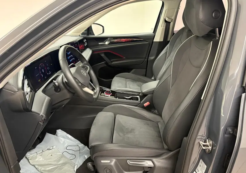 Vue intérieure côté conducteur du Volkswagen Tiguan 2025 gris Dauphin, avec sièges en cuir et tableau de bord numérique.