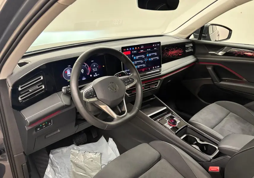 Vue intérieure côté conducteur du Volkswagen Tiguan 2.0 TDI 150 DSG7 Elegance, avec tableau de bord numérique et sellerie gris foncé.