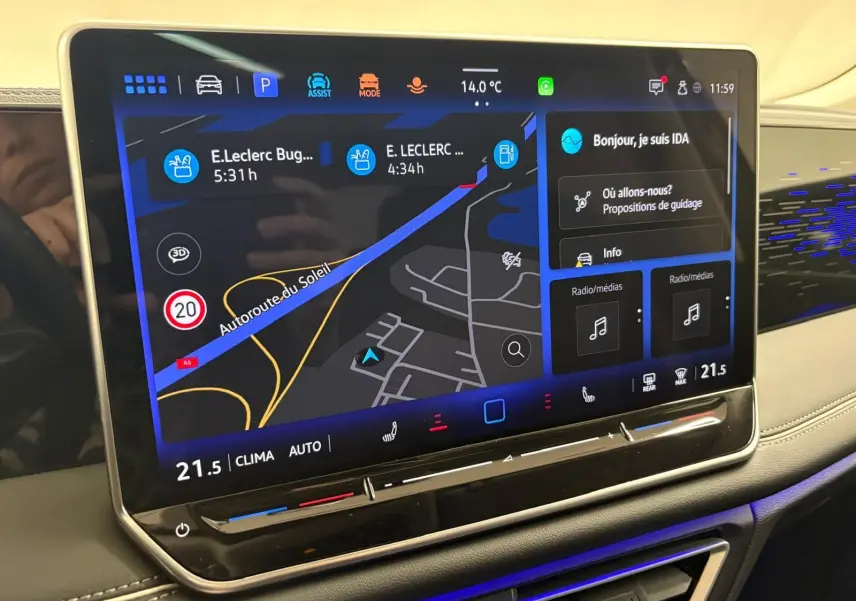Écran tactile central du Volkswagen Tiguan 2025 affichant la navigation et les commandes climatiques, intérieur gris clair.