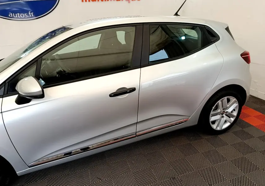 Vue latérale droite d'une Renault Clio Business TCe 100 gris clair, avec jantes alliage et poignées noires.