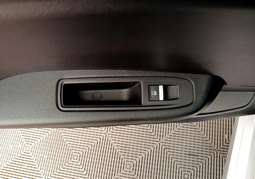 Détail de la commande de lève-vitre côté gauche intérieur d’une Renault Clio Business gris clair 2020.