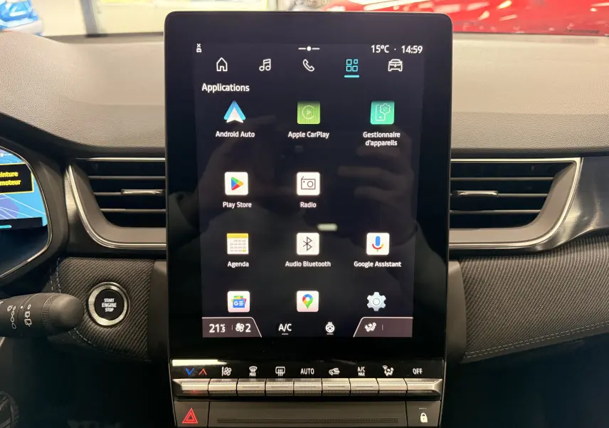 Vue intérieure centrée sur l'écran tactile vertical du tableau de bord du Renault Captur E-Tech 2026 avec commandes climatisation en bas.