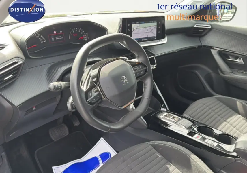 Vue intérieure côté conducteur du Peugeot 2008 2022, tableau de bord et volant avec écran tactile central en évidence.