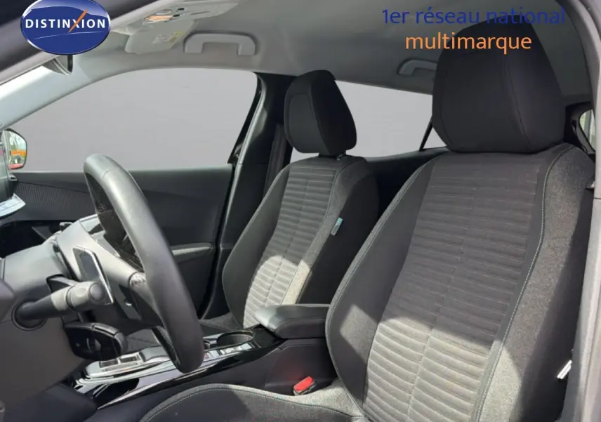 Vue intérieure côté conducteur du Peugeot 2008 2022, sièges tissu noir et console centrale brillante.