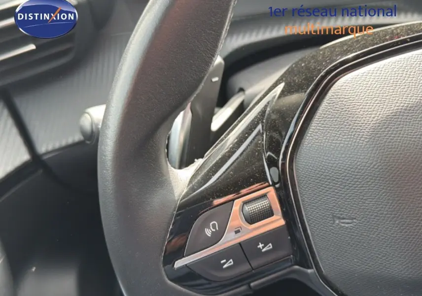 Gros plan sur le volant noir du Peugeot 2008 2022, mettant en valeur les commandes audio intégrées.