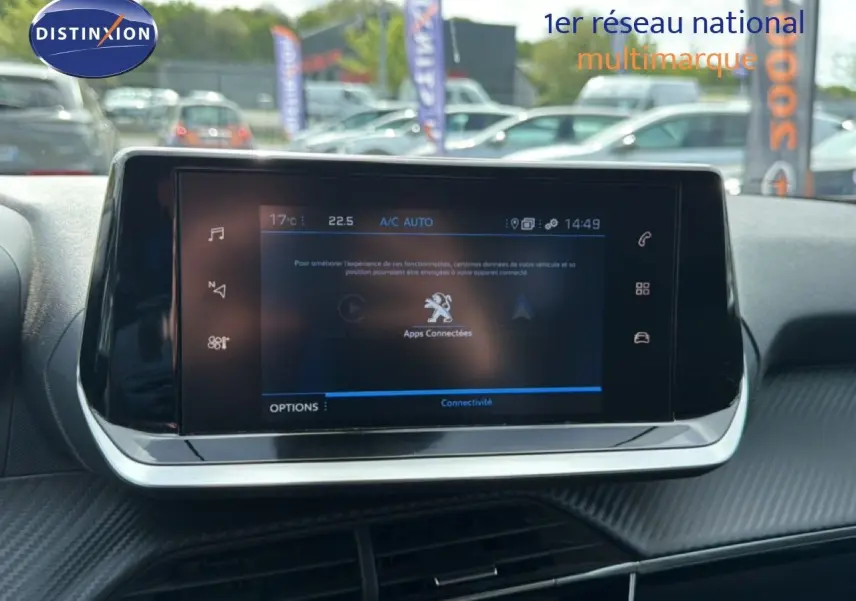 Écran tactile central du tableau de bord du Peugeot 2008 2022, affichant les applications connectées en extérieur flou.