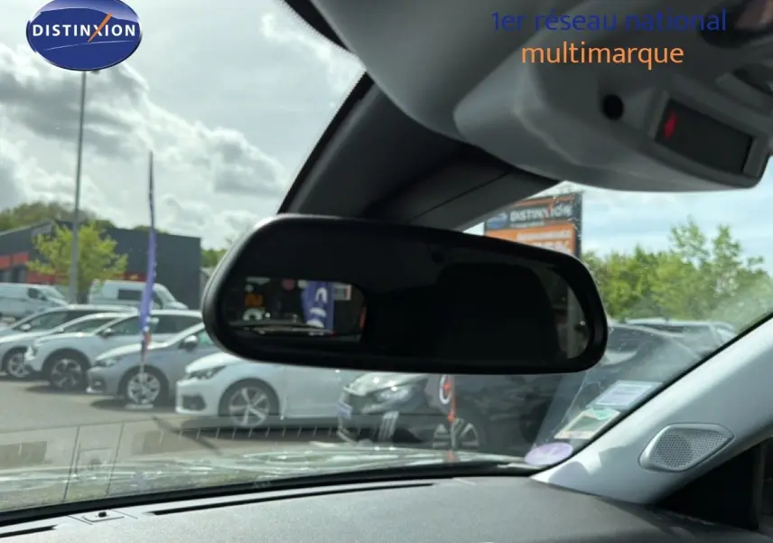 Vue intérieure du rétroviseur central d'un Peugeot 2008 noir perle métal, avec tableau de bord et pare-brise visibles.