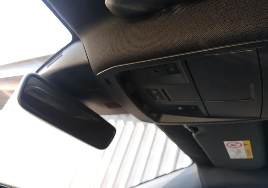 Vue intérieure du plafond avant du Peugeot 3008 nouveau gris titane, montrant le rétroviseur et les commandes d'éclairage.