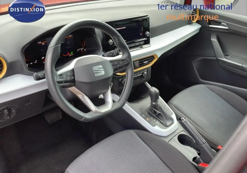 Vue intérieure avant droite du SEAT Arona 2025 avec volant cuir multifonction et sellerie tissu gris.