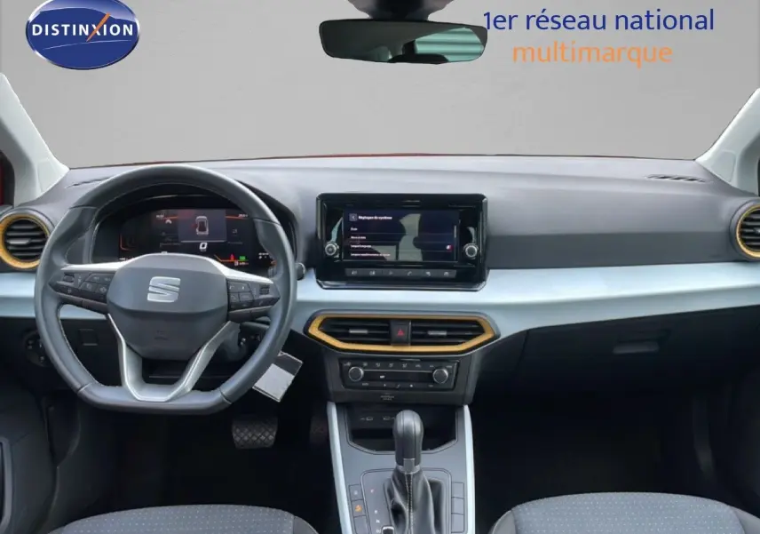 Vue intérieure du tableau de bord et volant de la SEAT Arona 2025, avec détails noirs et inserts dorés autour des aérateurs.