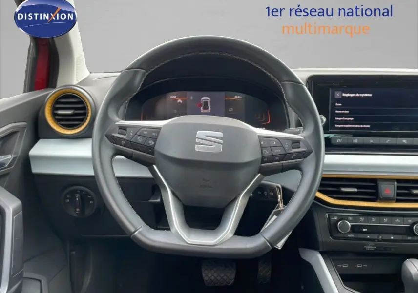 Vue intérieure centrée sur le volant cuir de la SEAT Arona 2025 avec tableau de bord et écran tactile.