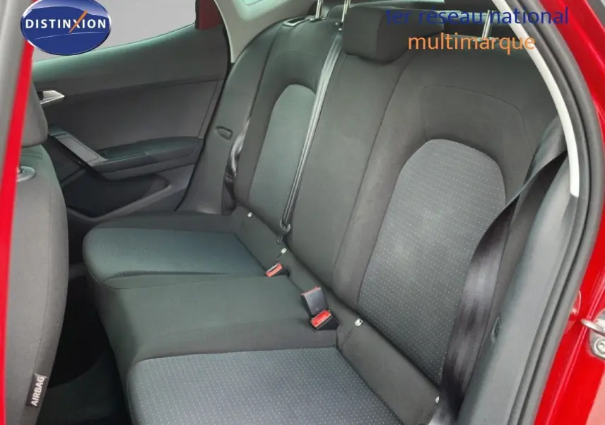 Vue intérieure côté droit des sièges arrière noirs d’un SEAT Arona rouge Désir Métal avec toit noir, porte arrière ouverte.