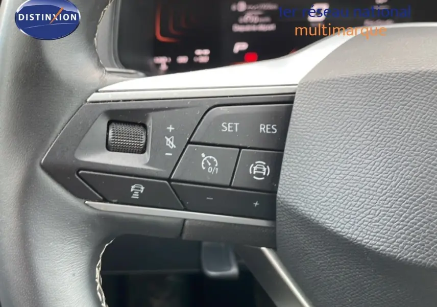 Gros plan sur les commandes au volant à gauche du SEAT Arona 2025, volant cuir noir avec boutons multifonctions.