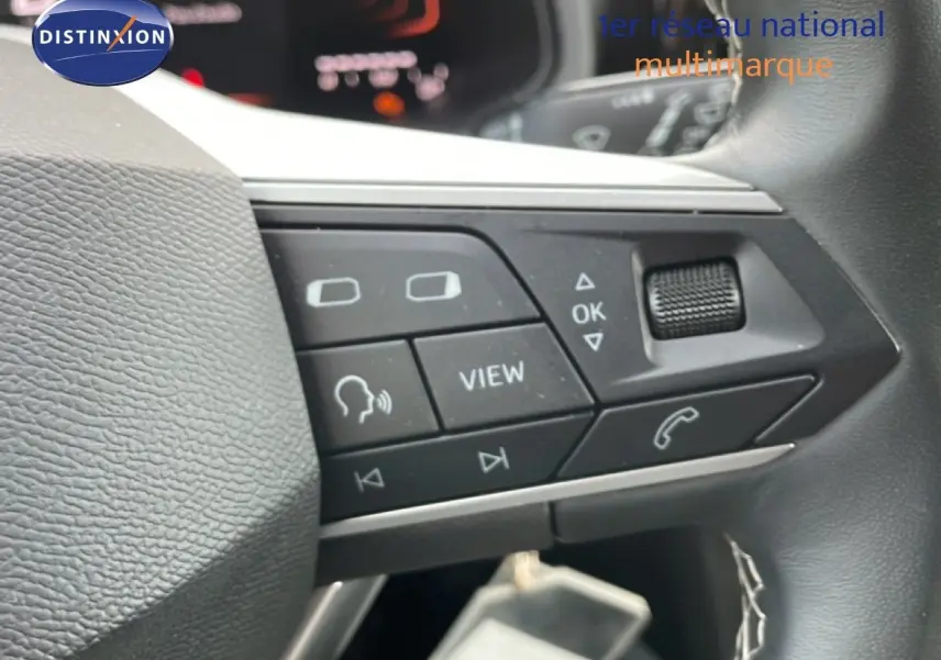 Gros plan sur les commandes multifonctions au volant d’un SEAT Arona rouge Désir Métal avec toit noir, version 2025.