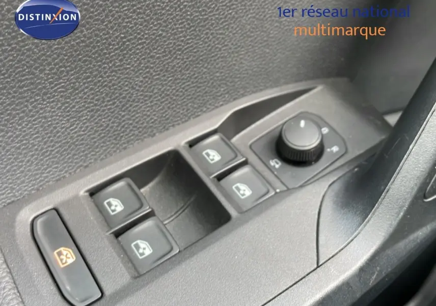 Gros plan sur les commandes de lève-vitres et rétroviseurs côté conducteur d’une SEAT Arona rouge désir métal avec toit noir.