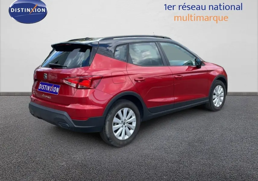 Vue 3/4 arrière droite d'un SEAT Arona rouge désir métal avec toit noir, roues argentées et détails noirs.