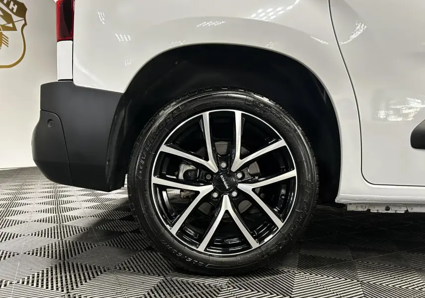 Gros plan sur la roue arrière droite avec jante alu 17 pouces du Peugeot Partner blanc Banquise 2025.