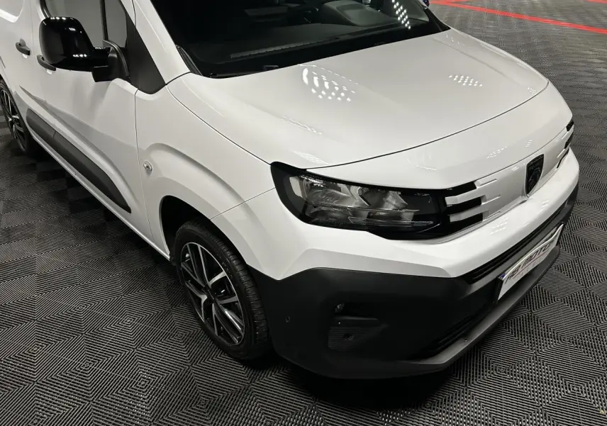 Vue 3/4 avant droit du Peugeot Partner blanc Banquise avec jantes alliage 17 pouces et détails noirs contrastants.