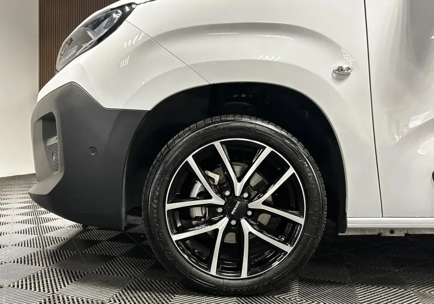 Vue côté avant droit du Peugeot Partner blanc Banquise mettant en valeur la jante alu 17 pouces bicolore.
