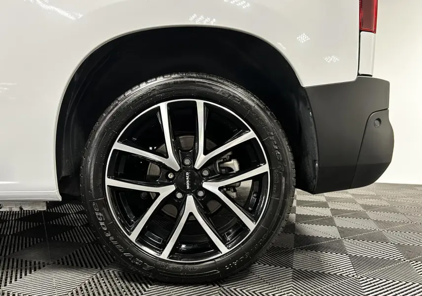 Gros plan sur la roue arrière droite avec jante alu 17 pouces du Peugeot Partner blanc Banquise 2025.