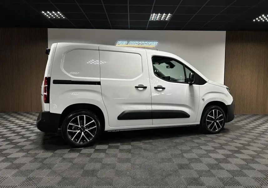 Vue latérale droite du Peugeot Partner blanc Banquise 2025 avec jantes alliage 17 pouces et protections noires.
