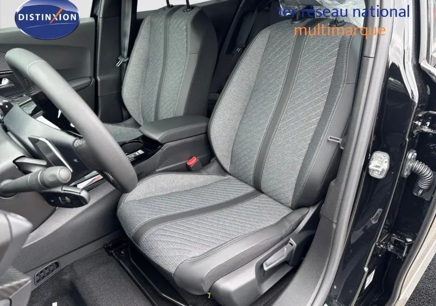 Intérieur du Peugeot 2008 Hybrid 136ch Allure 2025, siège avant droit en tissu gris et cuir noir, porte ouverte côté conducteur.