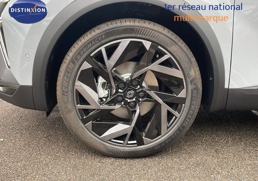 Gros plan sur la roue avant droite du Renault Symbioz gris Rafale Métal avec jante noire et argentée au design géométrique.