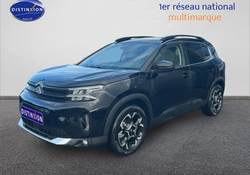 Citroën C5 Aircross noir vue 3/4 avant droit avec jantes alu et barres de toit visibles.