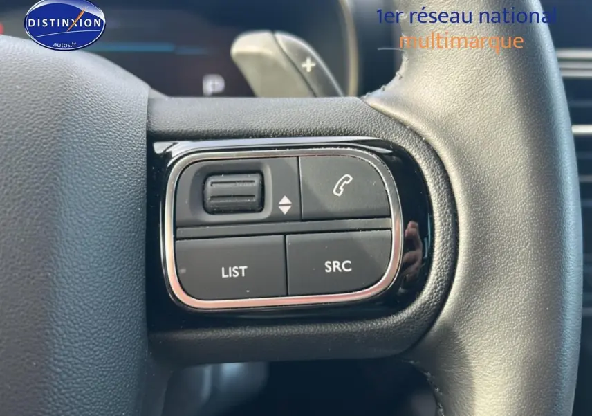 Gros plan sur les commandes multifonctions à gauche du volant cuir noir du Citroën C5 Aircross 2025.