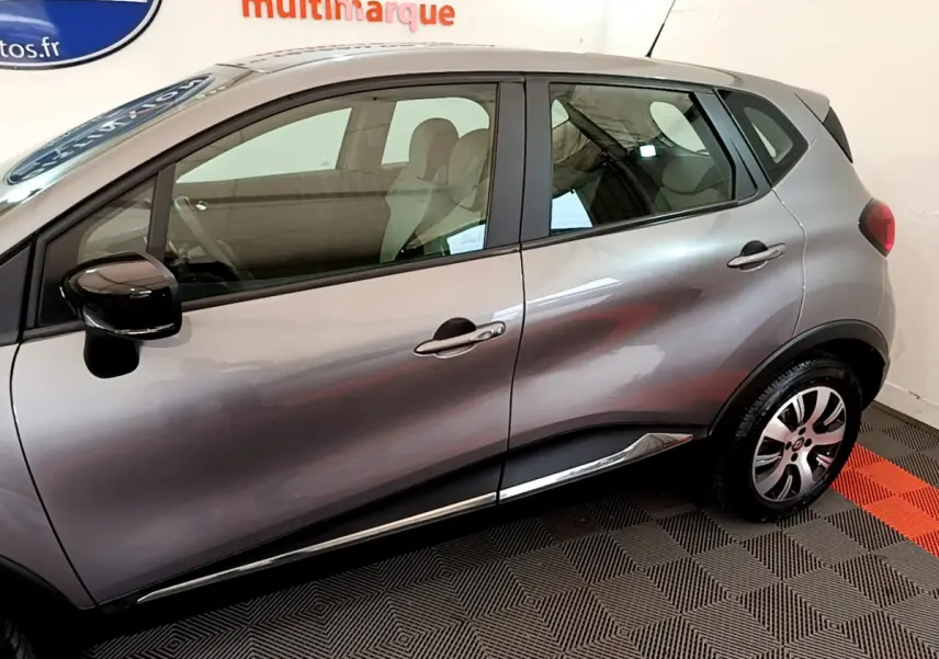 Vue côté droit du Renault Captur gris foncé de 2018, mettant en valeur les portes et la jante alliage.