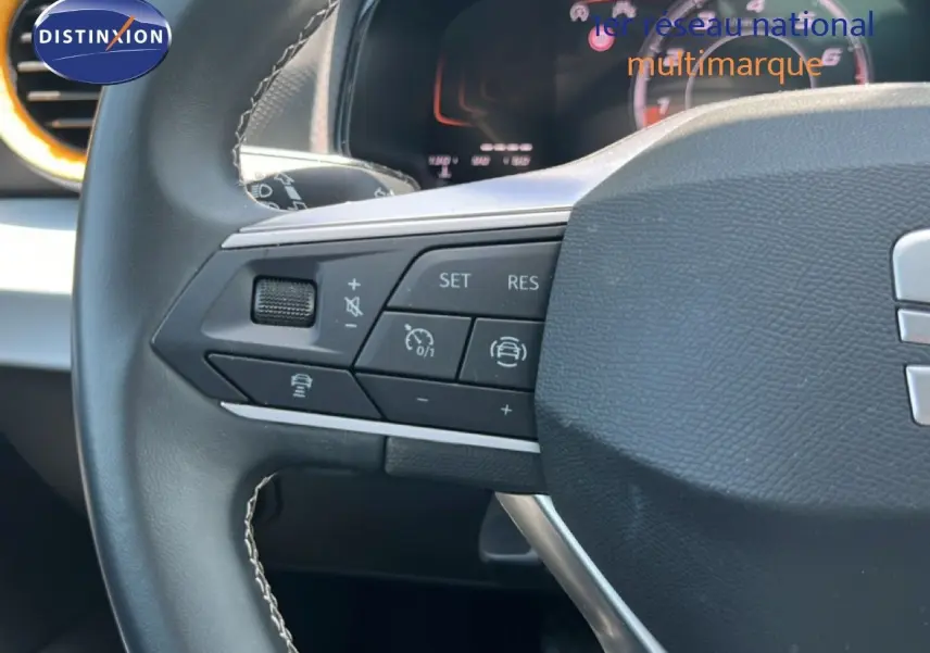 Gros plan sur le volant noir de la SEAT Arona 2025, montrant les commandes multifonctions côté gauche.