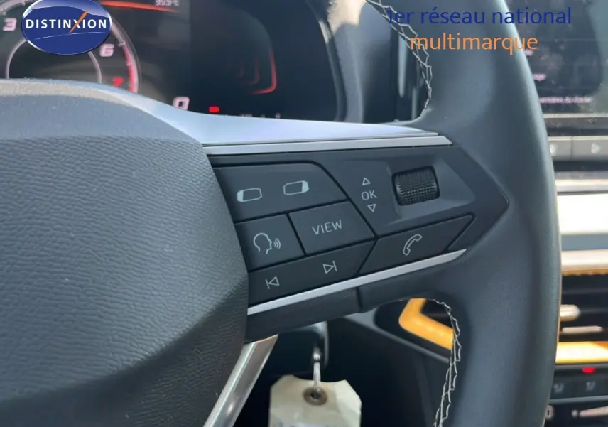Gros plan sur le volant cuir noir de la SEAT Arona 2025 avec commandes multifonctions et coutures apparentes.
