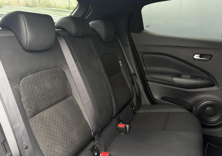 Vue latérale droite de la banquette arrière noire en tissu et TEP du Nissan Juke blanc perle 2024.