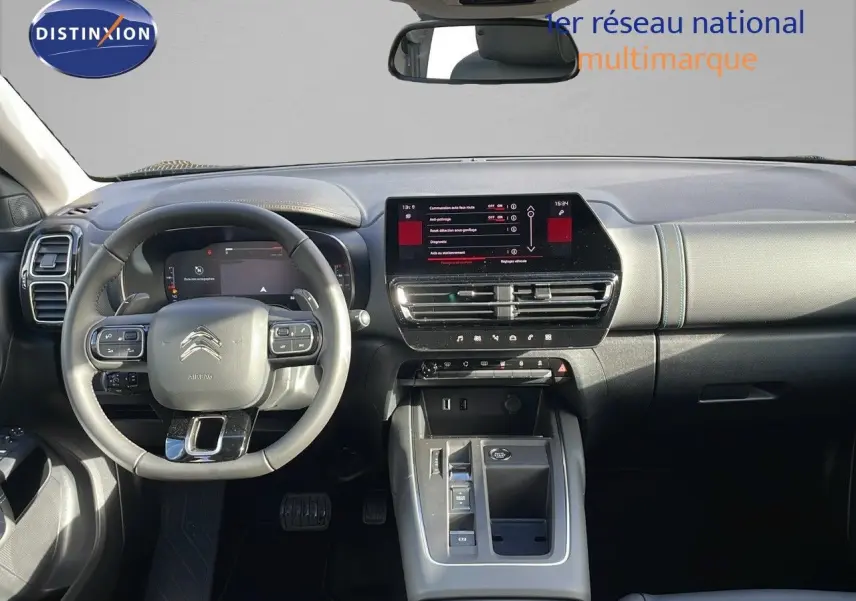 Vue intérieure frontale du tableau de bord et volant gris clair du Citroën C5 Aircross 2025 avec écran tactile central.