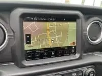 Vue rapprochée de l’écran tactile du GPS intérieur d’une Jeep Wrangler Unlimited 2023, affichant une carte de navigation.