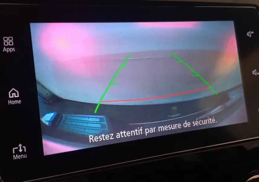 Vue de la caméra de recul du Mitsubishi L200 gris foncé, avec lignes de guidage vertes et rouges à l'écran tactile.