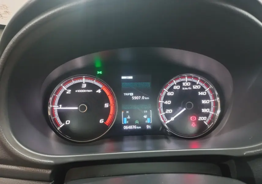 Vue rapprochée du tableau de bord du Mitsubishi L200 gris foncé, affichant compte-tours, vitesse et écran digital.