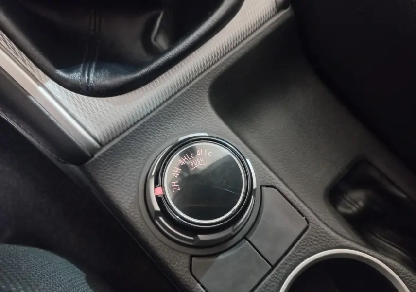 Gros plan sur le sélecteur de mode 4x4 dans l’habitacle noir du Mitsubishi L200 gris foncé, version 2020.
