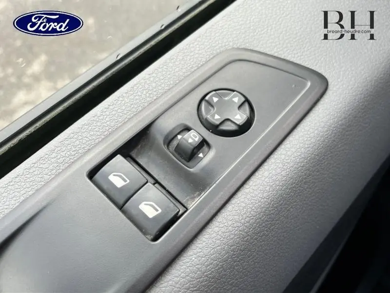 Gros plan sur les commandes de réglage des rétroviseurs et vitres électriques côté conducteur du Citroën Jumpy blanc Banquise.