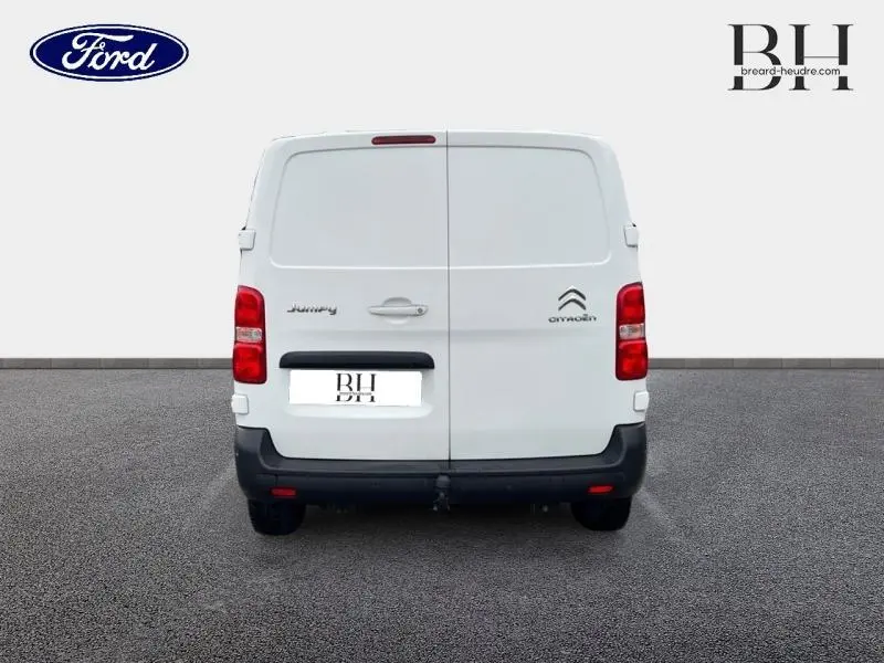 Vue arrière d'un Citroën Jumpy blanc Banquise avec portes battantes et attelage visible.